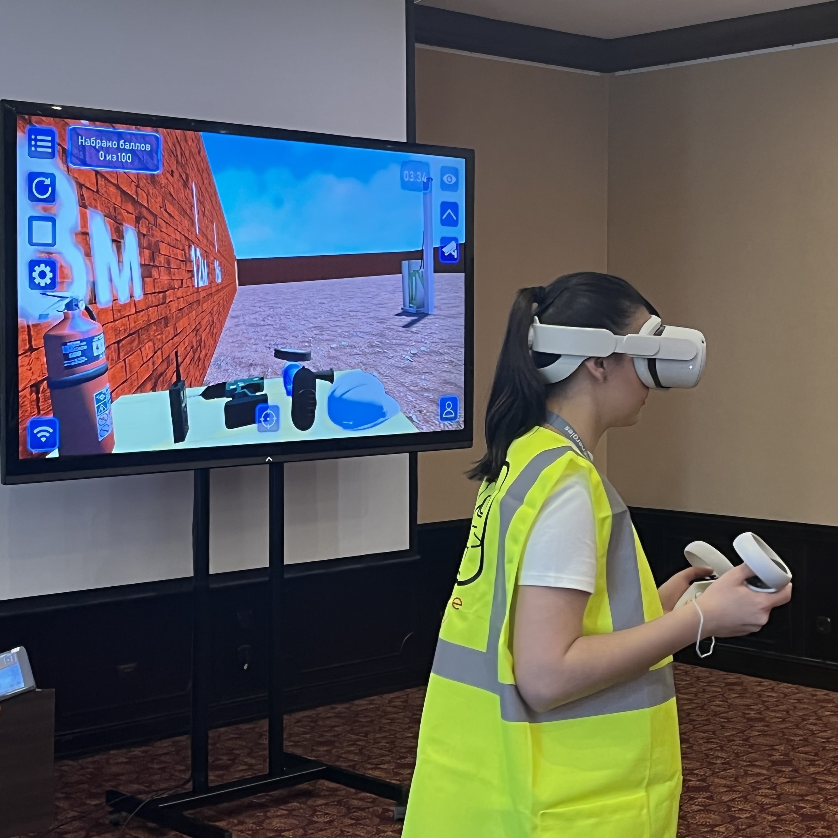 Участница занятия в VR-шлеме; изображение тренажёра выведено на общий экран